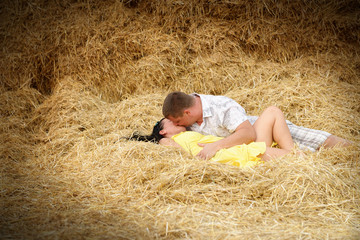 Naklejka na ściany i meble A couple in kissing at hay