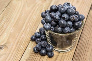 Blueberries in a glass on wood