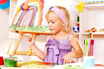 Child painting at easel.