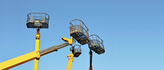 Four mobile platforms elevated towards a blue sky