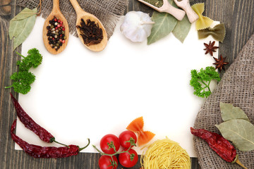 paper for recipes vegetables, and spices on wooden table