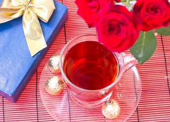 Tea with sweets and blue box, a bouquet of roses