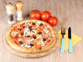 Aromatic pizza with vegetables on wooden background