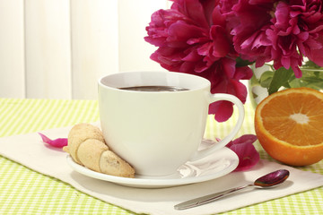 Obraz na płótnie Canvas kubek gorącej czekolady, ciastka i kwiaty na stole w kawiarni