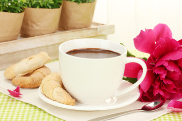 cup hot chocolate, cookies  and flower on table in cafe