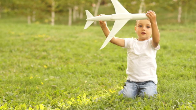 Future aircraft pilot playing with toy airplane outdoors