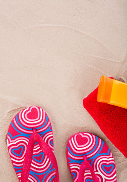Flipflops ,sunscreen,towel on sand beach