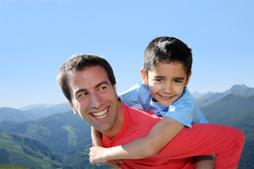 Portrait of father and son having fun in the mountain