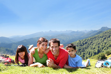 Portrait of happy family laying on the grass in mountain