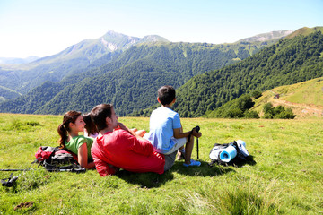 Fototapeta na wymiar Rodzina ustanawiające trawę korzystających widok na góry