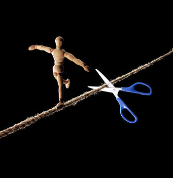 Tijera cortando la cuerda de un equilibrista.