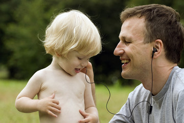 Happy father and the son listen to music