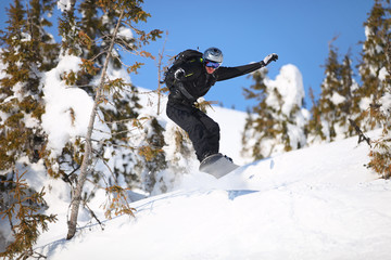 Snowboarder jumping on mountain slope