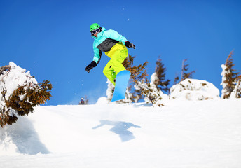 Snowboarder jumping on mountain slope