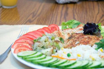 Grilled chicken with rice, lettuce, tomatoes and cucumbers