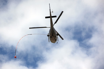 Fototapeta na wymiar Rescue helicopter moving in blue sky with clouds