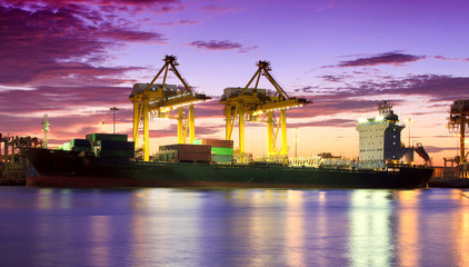 Container Cargo freight ship with working crane bridge in shipya