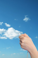 Conceptual human hand holding a internet data cable in clouds