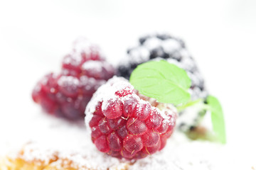 cake with icing, raspberry, blackberry and mint  on a white back