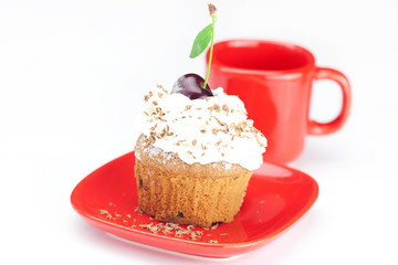 muffin with whipped cream, cherries and red cup on white backgro
