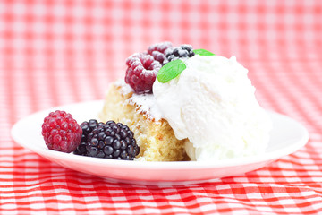 cake with icing,icecream, raspberry, blackberry and mint on a pl