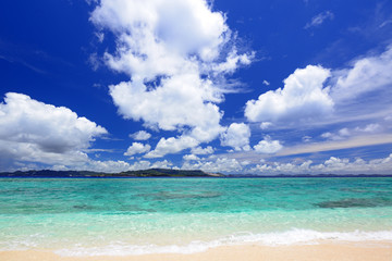 Fototapeta premium 南国沖縄の美しいビーチに打ち寄せる透明な波と夏空