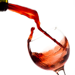 Red wine pouring down into a wine glass