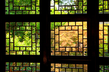 Old Chinese window in Shanghai facing a lush courtyard garden