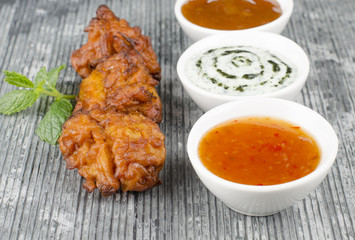 Onion Bhajis, mango chutney, mint raita & chili dip on a slate