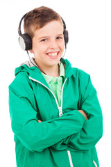 Young casual boy listening to music on headphones against white