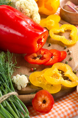 Fresh yellow and red pepper on the wooden board