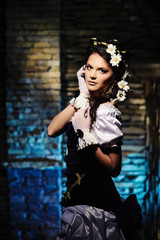 Girl with chamomile in the hair in vintage dress