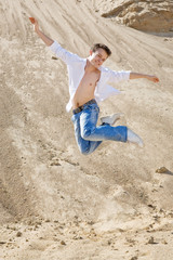 Young man jumping in the sand