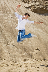 Young man jumping in the sand