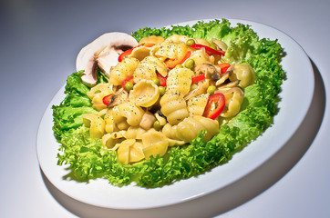 Pasta with mushrooms, bacon, pea pods and salad.