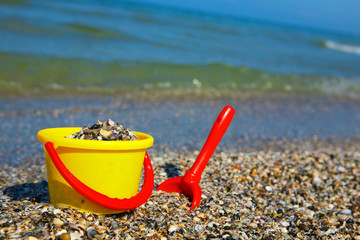 Plastic spade and bucket in sand