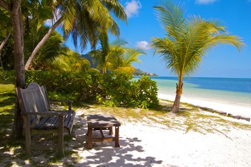 Wooden bench and footrest at a white sands beach, Seychelles
