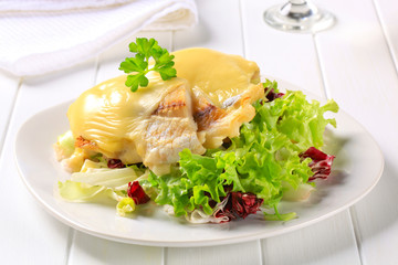 Cheese topped fish fillets with salad