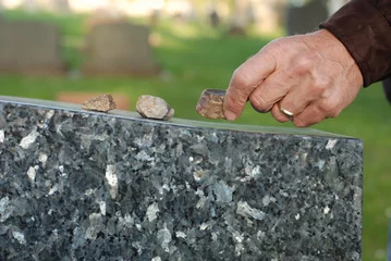 Photo sur Aluminium Monument Placing stone on tombstone