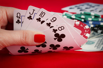 Woman's hand holding playing cards straight flush