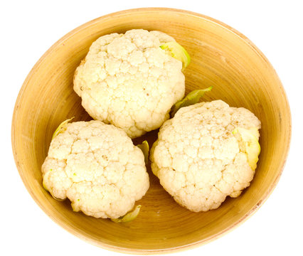 Fresh cauliflower in wooden bowl isolated on white