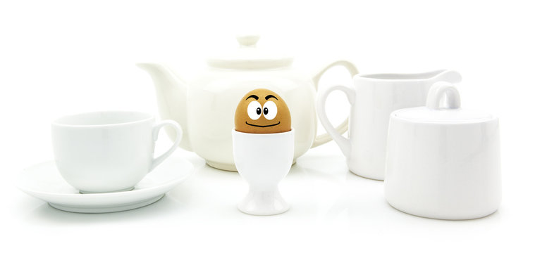 Breakfast egg with happy face tea pot and cup on white backgroun