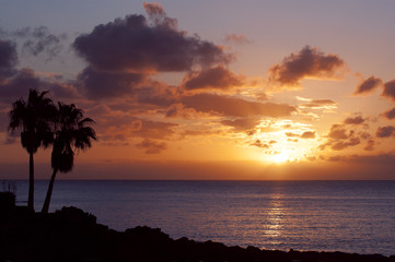 Fototapeta na wymiar pomarańczowy zachód słońca na tropikalnej wyspie z palmami