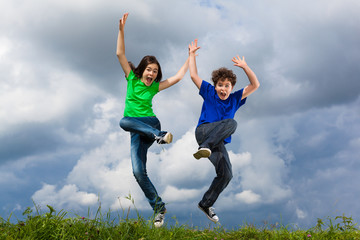 Girl and boy running, jumping outdoor