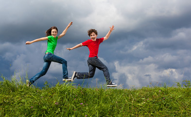 Fototapeta na wymiar Girl and boy jumping, running outdoor