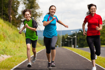 Obraz premium Active family - mother and kids running outdoor