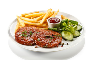 Grilled steaks, French fries and vegetables