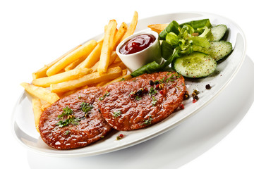Grilled steaks, French fries and vegetables