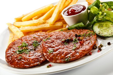 Grilled steaks, French fries and vegetables