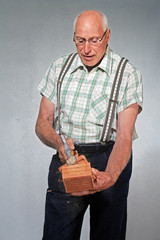 aged mason cleaving a brick workmanlike